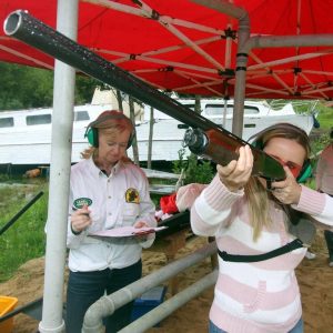 Girl shooting a shotgun clay pigeon