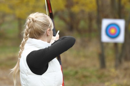 Girl shooting an arrow at a target, archery